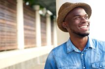 smiling African American man wearing a hat looking confident