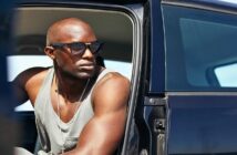 bald African American man sitting in his car with the door open - illustrating the idea of someone who commands respect from others