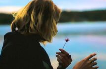 16 Signs Of A Hopeless Romantic—What It Means To Be One young woman picking petals from a flower to show she is a hopeless romantic