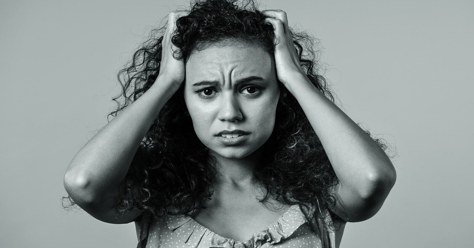 woman struggling with thought loops holding her head in despair