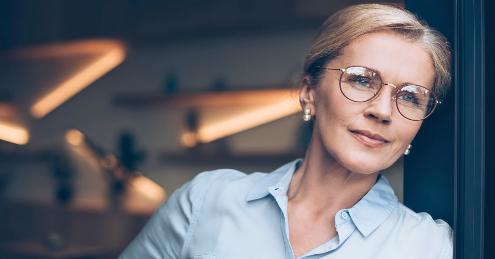 pensive middle-aged woman wearing smart blouse and glasses