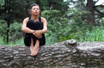 woman sitting on a fallen tree surrounded by nature - illustrating a spiritual person