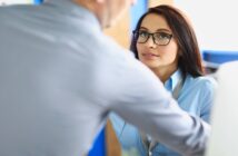 The 7 Types Of Attraction A Person Might Feel In Their Relationships attractive woman with glasses looking longingly at a male colleague as he reaches across her to get something