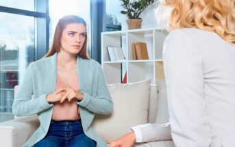 nervous looking young woman talking about her problems to a therapist