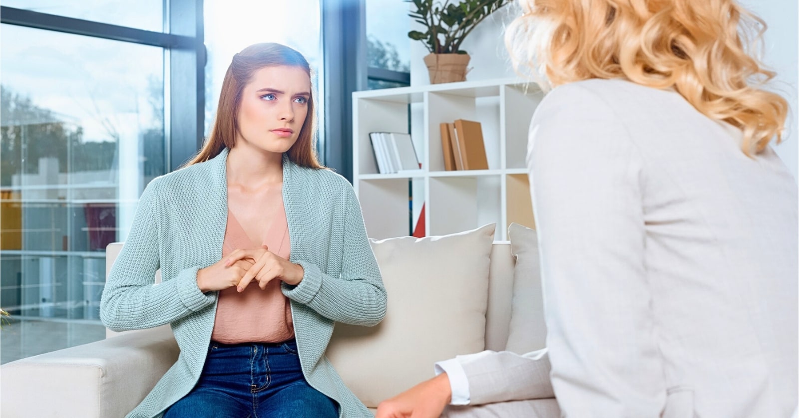 nervous looking young woman talking about her problems to a therapist