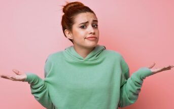 young woman in green hoodie shrugging her shoulders as if to say "I don't know"