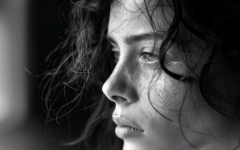 black and white closeup photo of a young woman with a tear near her eye