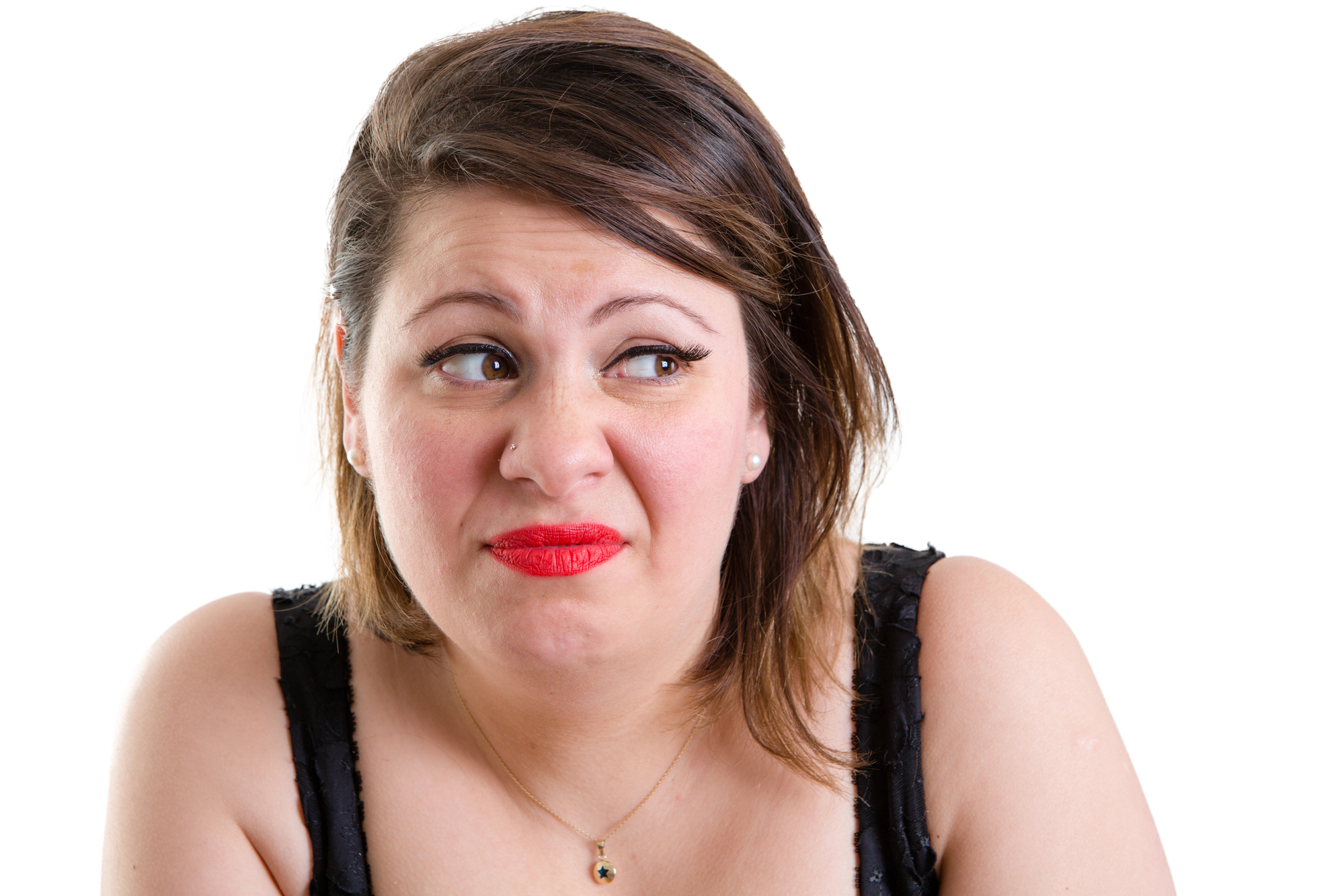 A woman with medium-length brown hair and red lipstick is making a disgusted or uncomfortable facial expression. She is wearing a black sleeveless top and a necklace with a small pendant. The background is plain white.