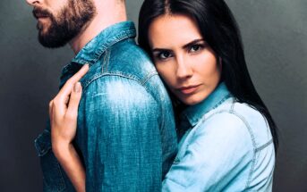 If you’ve crossed the line from loving to needy, you’ll display 12 common behaviors in your relationship A woman with long dark hair embraces a bearded man from behind. Both are wearing denim shirts. The man faces away, while the woman looks directly at the camera with a serious expression. The background is a muted gray.