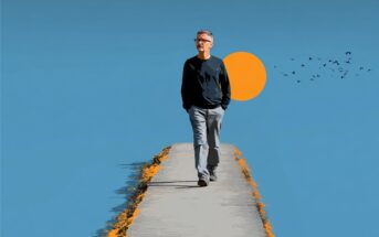A man with glasses walks alone on a narrow path under a clear blue sky, with an orange sun and a flock of birds in the background.