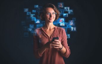 A woman with glasses and a short brown bob smiles while holding a smartphone. Behind her, floating digital photo thumbnails form a semi-circle, suggesting she is browsing or interacting with media.