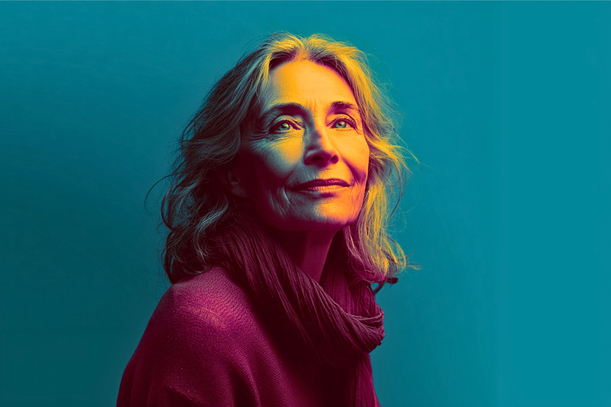 A mature woman with wavy hair looks upward, softly smiling. She wears a scarf and sweater. The portrait uses dramatic, colorful lighting with blue and yellow tones against a blue background.