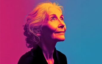Elderly woman with gray hair looks upward, softly smiling. Image uses dramatic pink, orange, and blue lighting on a plain background, creating a vibrant, artistic effect.