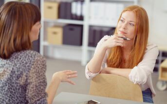 two women colleagues having a conversation in an office