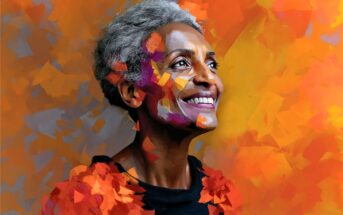 A smiling older woman with short gray hair stands against a vibrant, abstract orange and yellow background. Her face and clothing blend with colorful, painted brushstrokes, creating an artistic, joyful atmosphere.