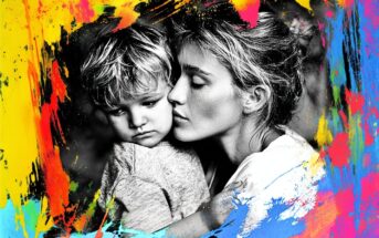 A black-and-white photo of a woman hugging a young child, surrounded by a vibrant, colorful paint splash border in yellow, red, blue, and pink. The mood is tender and affectionate.
