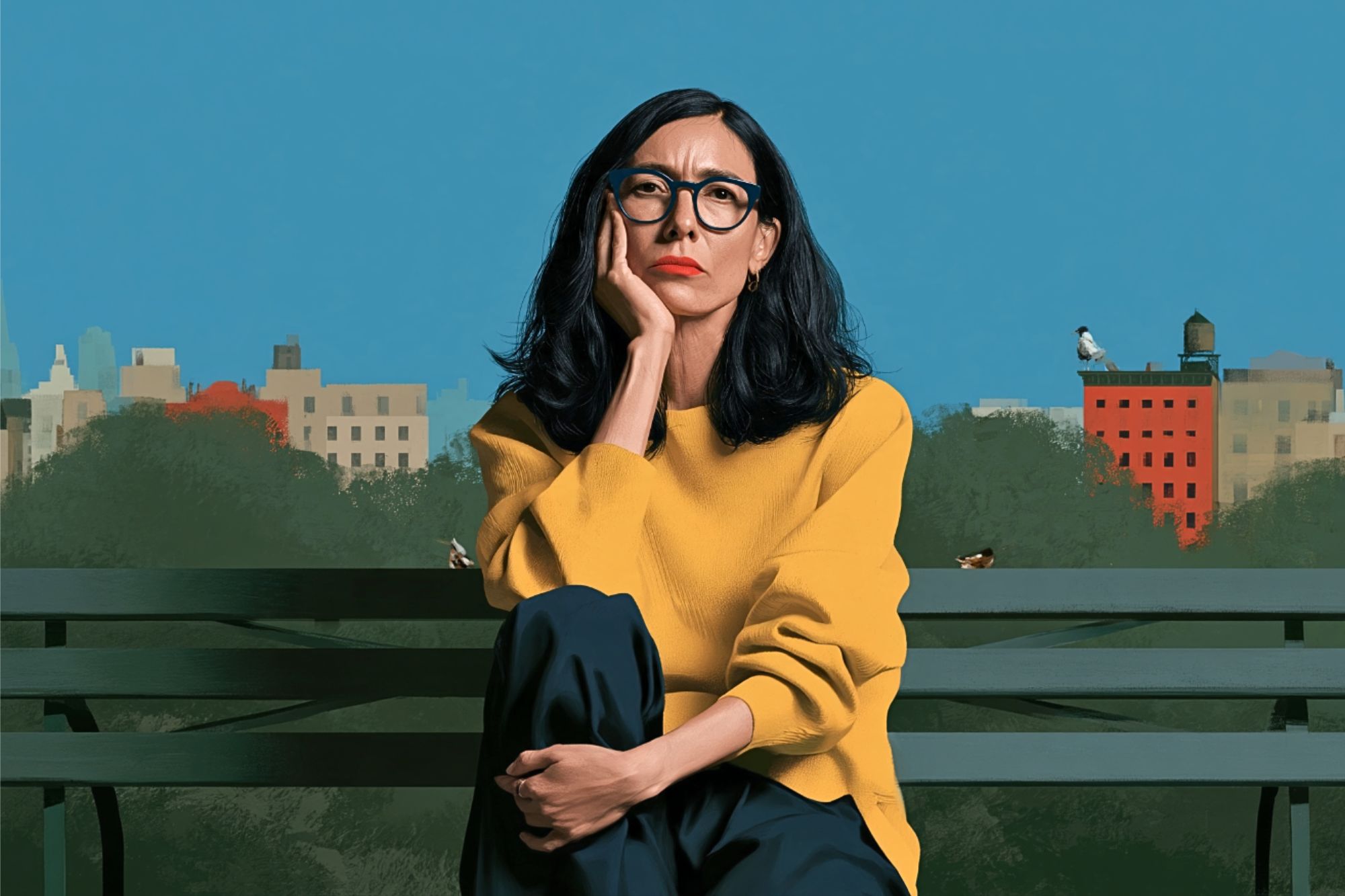 A woman with dark hair and glasses wears a yellow sweater and sits on a park bench in front of a city skyline.