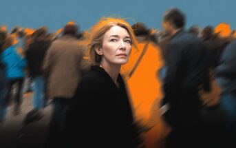 A woman with reddish hair looks up pensively, standing still amid a blurred crowd of people moving around her. The background is dark and blue, with orange highlights, making her stand out in sharp focus.
