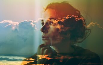 A double exposure image of a woman gazing thoughtfully into the distance, overlaid with colorful clouds and sunlight, creating a dreamy, contemplative atmosphere.