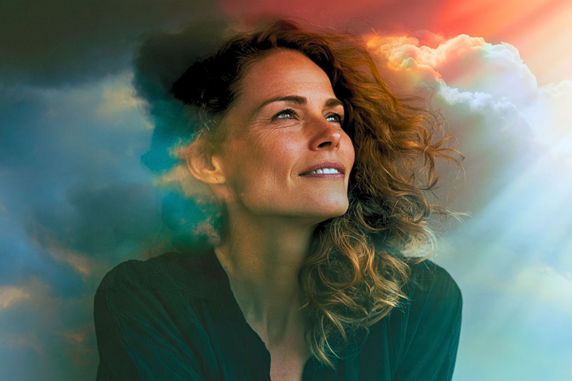 A woman looking upward, with a double exposure effect blending her profile into a cloudy sky with rays of light.