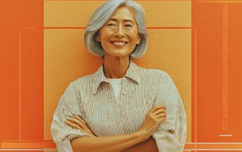 A smiling older woman with gray hair and a striped shirt stands with her arms crossed in front of an orange and yellow geometric background.