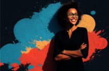 A smiling woman with curly hair and glasses stands confidently with arms crossed, in front of a dark background featuring vibrant blue, red, and orange paint splashes.