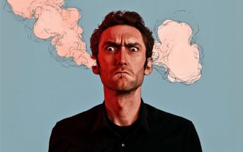 A man with an angry expression has pink smoke cartoonishly coming out of his ears, against a plain blue background.