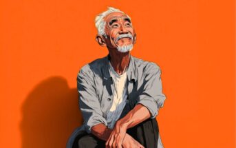A smiling older man with white hair and a beard sits cross-legged, looking upward. He wears a light shirt over a t-shirt. The background is a bright orange.
