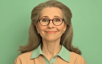 A smiling older woman with long gray hair, wearing round glasses, gold earrings, and a beige collared shirt with a mint green collar, stands in front of a solid mint green background.