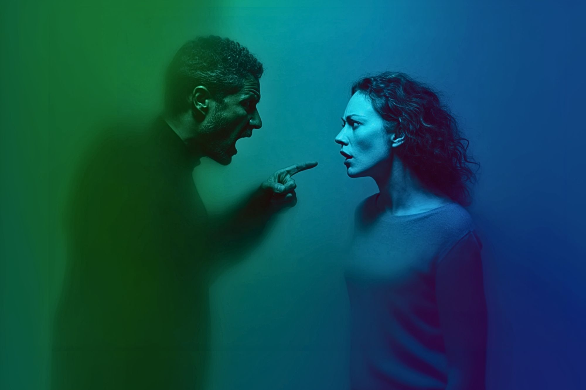 A man with an angry expression shouts and points at a woman who looks shocked. The scene is lit with green and blue light.