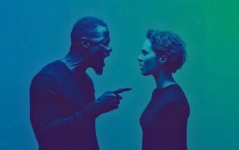 A man angrily yells and points his finger at a woman, who looks back at him with a concerned expression. The image is tinted in blue and green tones.