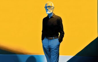 An older man with white hair and glasses stands against a vibrant yellow background, hands in his pockets, wearing a dark shirt and light pants.