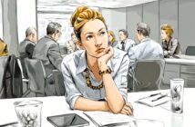 A woman sits at a conference table, resting her chin on her hand and looking thoughtful, while several people engage in discussion in the background. Papers, glasses of water, and a tablet are on the table.