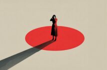 A person in a red dress stands covering their face on a large red circle against a beige background, casting a long shadow behind them.