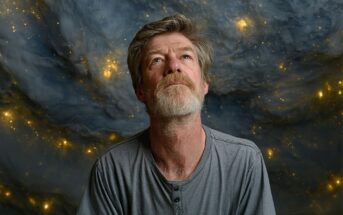 A man with a gray beard and hair in a gray shirt looks upward, standing in front of a dramatic cosmic background with swirling clouds and glowing stars.
