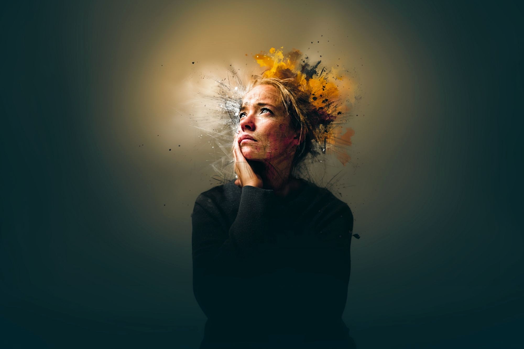 A woman with a thoughtful expression rests her chin on her hand. Abstract splashes of color, mainly yellow and orange, radiate from her head, symbolizing intense thoughts or creativity. The background is dark and blurred.