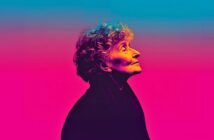 An elderly person with curly hair is shown in profile, looking upward. The image uses vibrant, gradient lighting with blue, pink, and purple tones, creating a surreal and artistic effect.