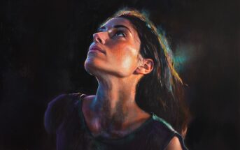 A realistic painting of a woman with long dark hair gazing upward, illuminated by dramatic, colorful lighting against a dark background. Her expression appears thoughtful or hopeful.