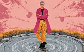 A person with short gray hair, glasses, a pink coat, and yellow patterned pants stands confidently with arms crossed in the center of a circular pool, surrounded by rocks and yellow grass, against a pink splattered background.
