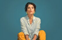 A digital illustration of a woman with dark hair in a loose bun, wearing a white shirt and yellow pants, sitting against a plain teal background and looking confidently at the viewer.