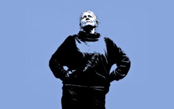 A stylized image of a person standing with hands on hips, looking upward against a solid blue background. The person is wearing a dark sweater and appears confident and contemplative.