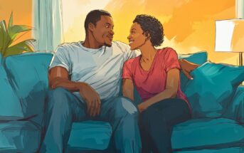 A couple sits close together on a blue couch, smiling and gazing at each other warmly in a cozy, sunlit living room with a lamp and plant in the background.