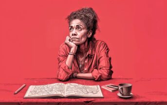 A woman sits at a table with a map, looking thoughtfully upward. She rests her chin on her hand and wears a red shirt. On the table are a pen, a notebook, and a cup of coffee. The background is solid red.