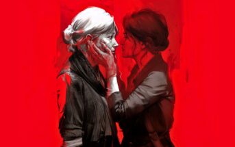 Two women stand close together against a vivid red background. One gently holds the other's face with both hands, their expressions intense and intimate, suggesting a deep emotional connection between them.