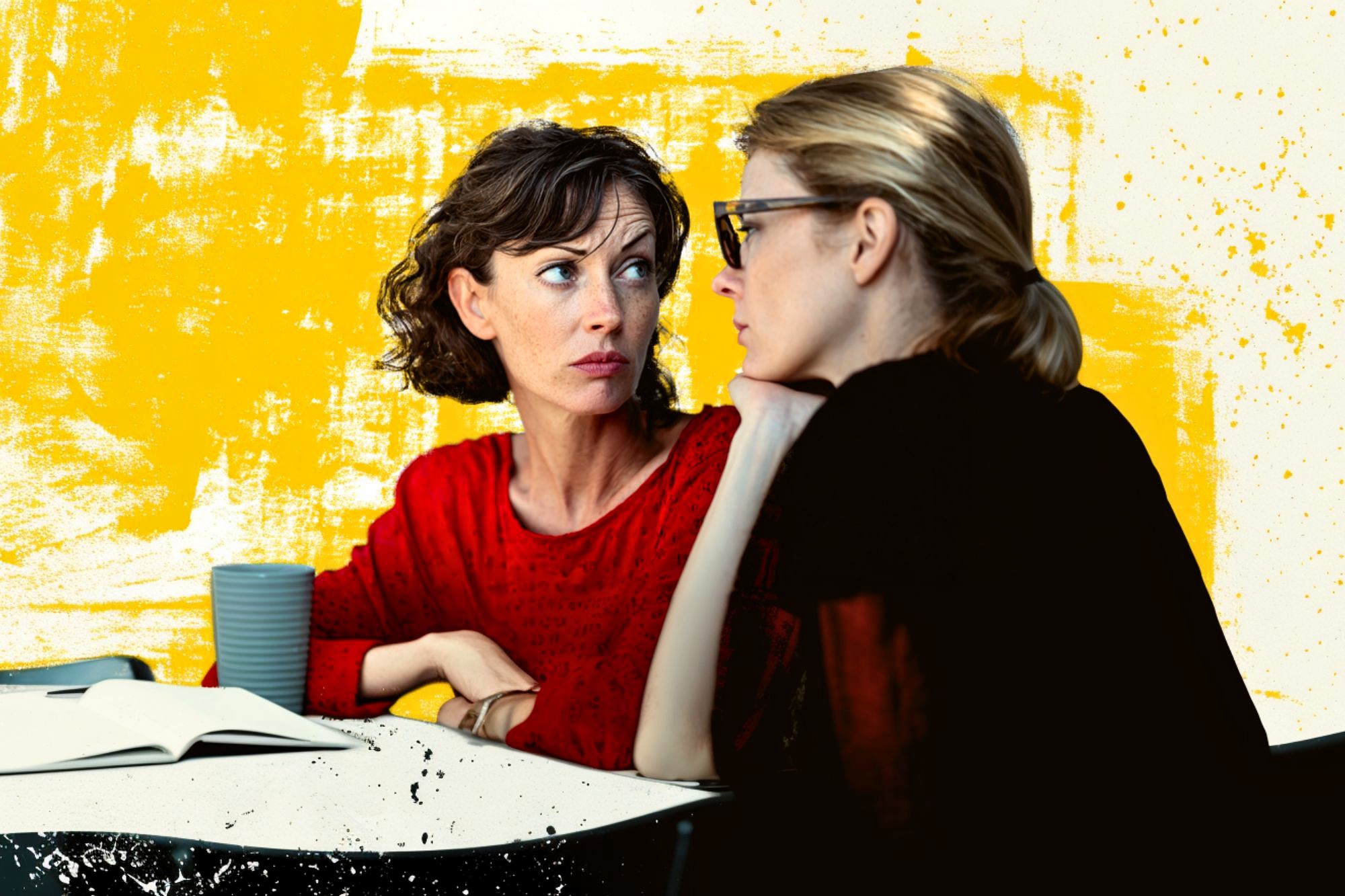 Two women sit at a table with an open notebook and a cup, engaged in a serious conversation. One woman in red looks concerned, while the other listens intently. The background is yellow with artistic splashes.