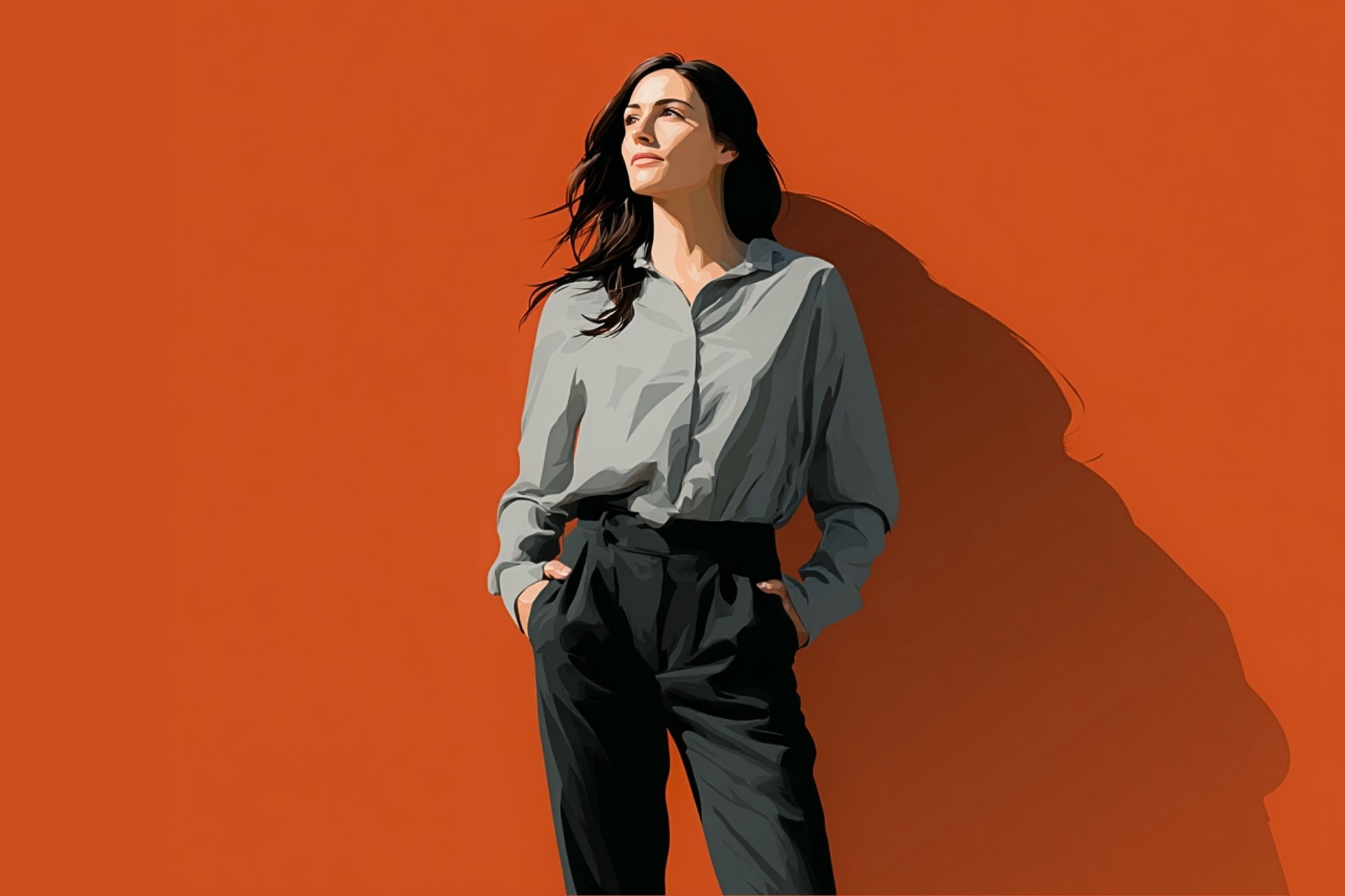 A woman with long dark hair stands against an orange background, wearing a light gray shirt and black pants, hands in pockets, looking confidently to the side.