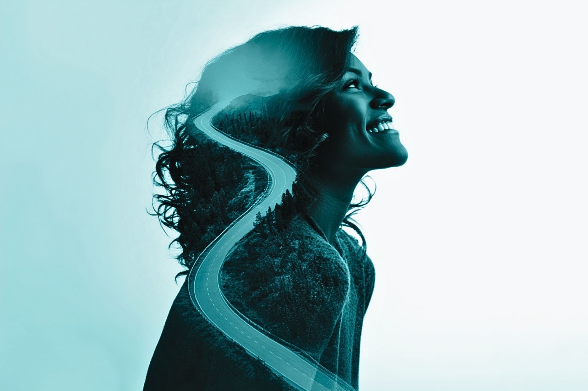 A double exposure image of a smiling woman in profile with a winding road and forest overlaid, symbolizing a journey or path within her silhouette.