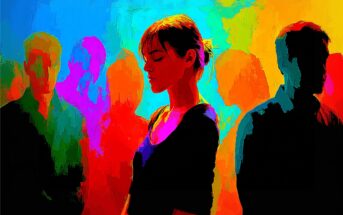 A woman stands with eyes closed amid colorful, abstract silhouettes of people, suggesting themes of isolation or introspection within a crowd.