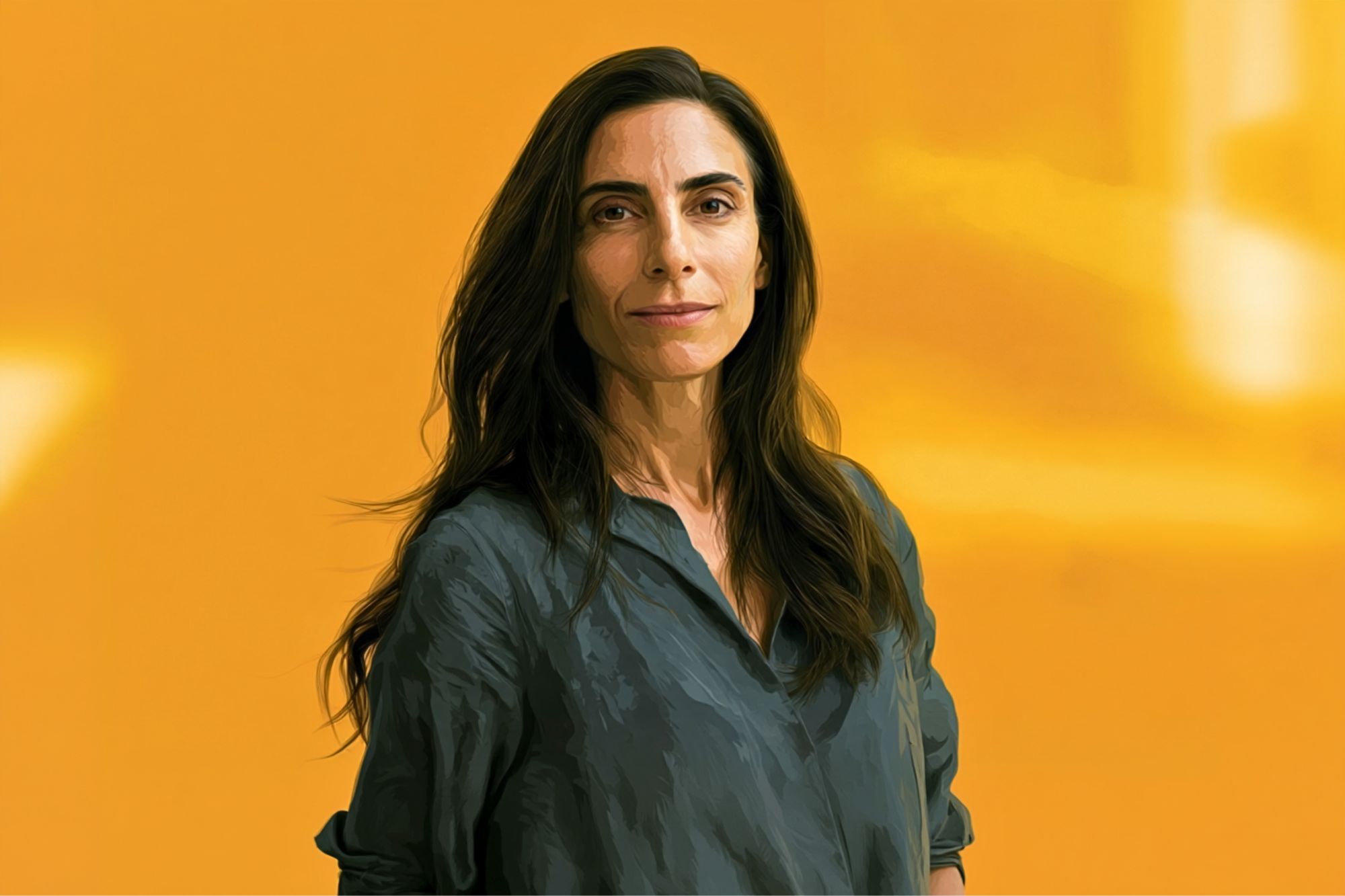 A woman with long brown hair wearing a loose gray shirt stands against a solid yellow background, looking confidently at the camera.