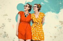 Two women in sunglasses smile and stand together. One wears a red dress with a statement necklace; the other wears a yellow polka dot dress. The background is teal with abstract shapes and a worn, textured look.